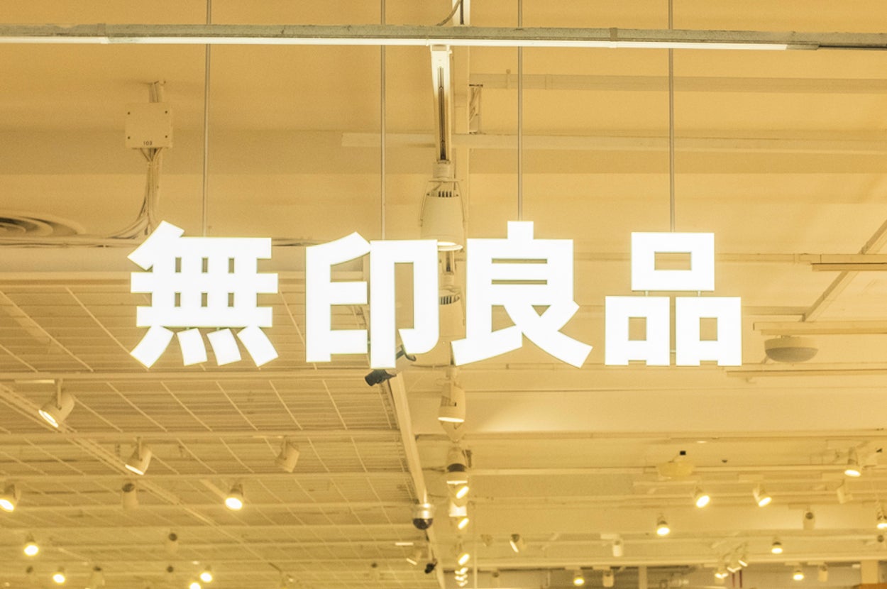 無印良品の店内の様子。棚に商品が並び、買い物客が店内を歩いている。明るい照明が特徴的なインテリアデザイン。