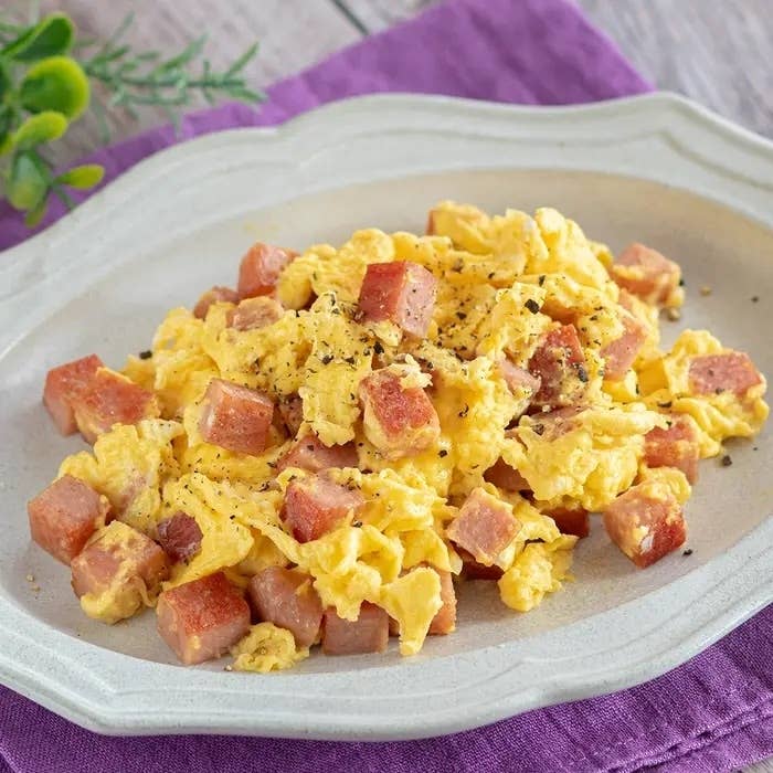 スクランブルエッグと角切りハムがミックスされ、お皿に盛られた料理。シンプルで食欲をそそる見た目。