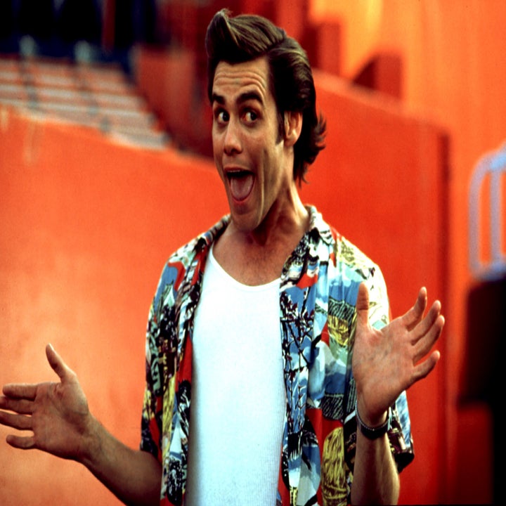 Person in a tropical shirt and white undershirt posing with an animated expression