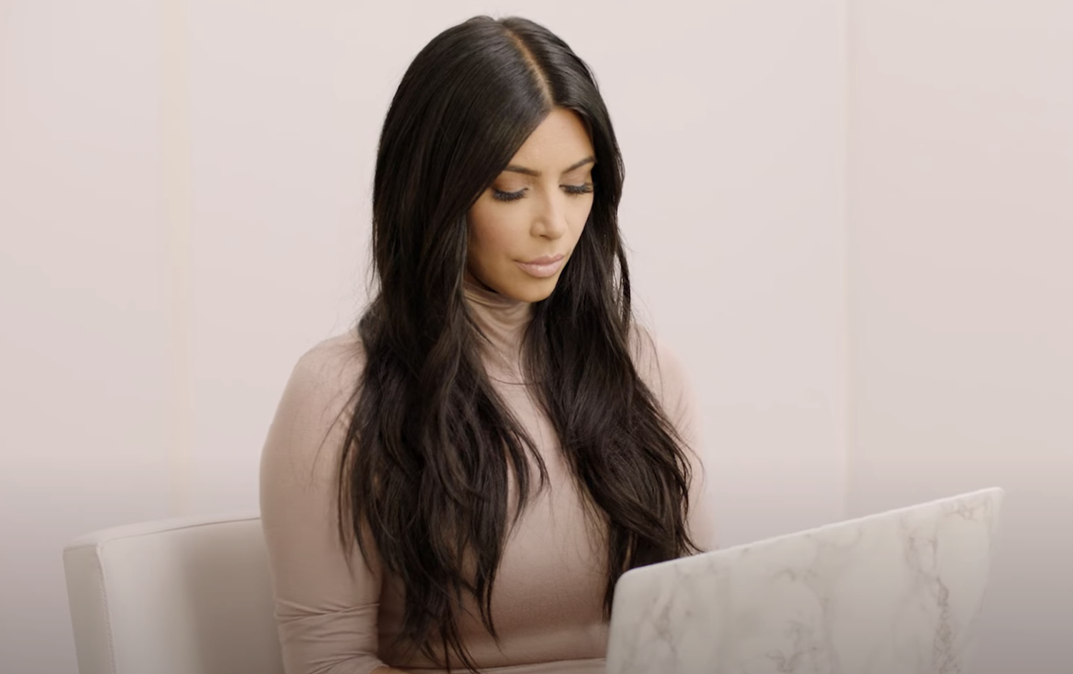 Kim Kardashian ngồi và nhìn vào máy tính xách tay