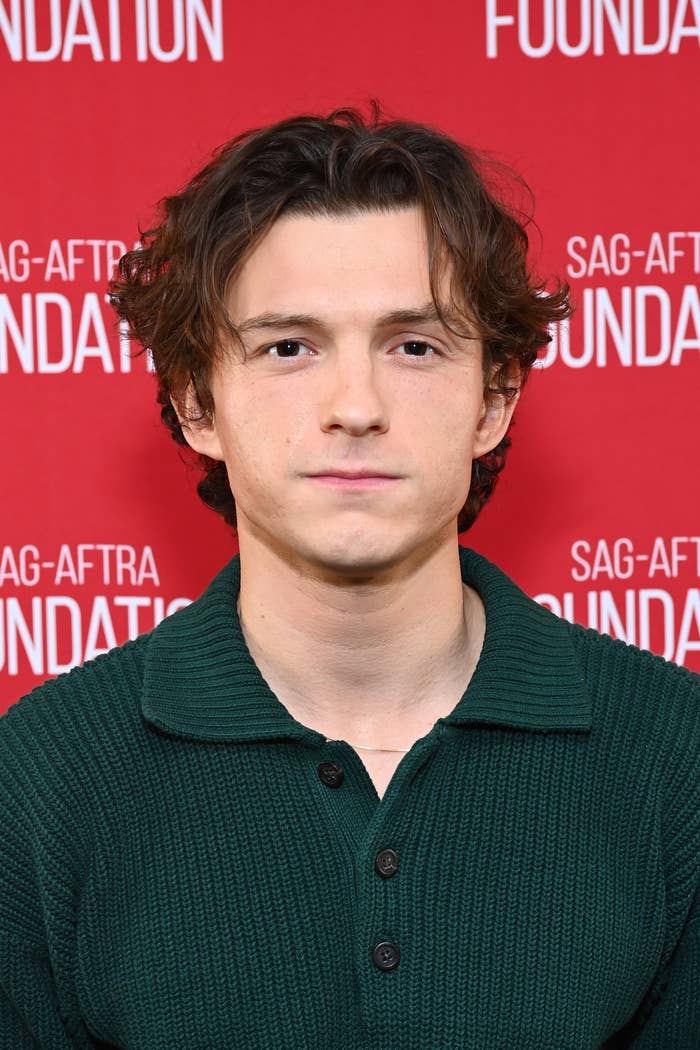 Tom Holland wearing a dark collared shirt at a SAG-AFTRA Foundation event backdrop