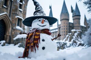 Snowman wearing a witch hat and scarf, smiling in front of a castle with tall spires, surrounded by snow