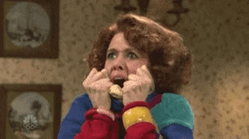 A woman with a shocked facial expression bites her fists, conveying extreme surprise or anxiety