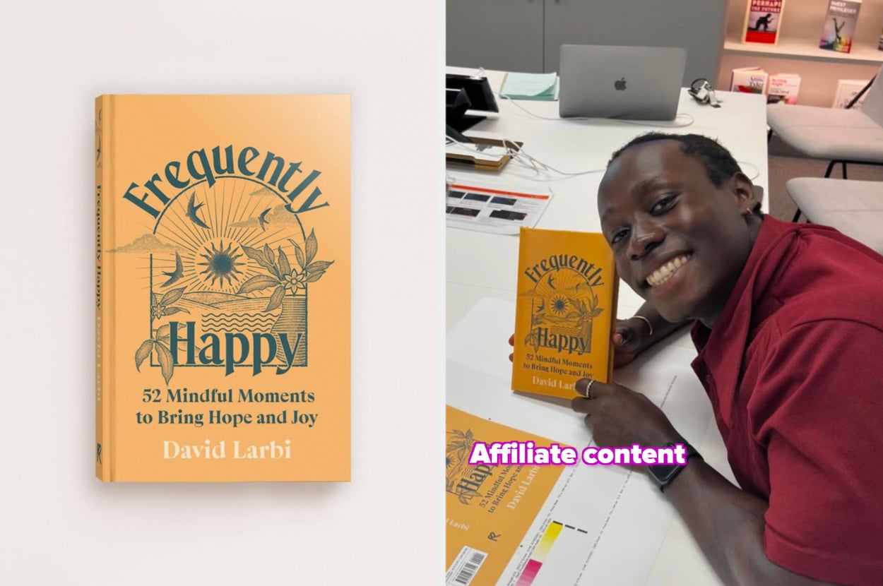 Person smiling at a desk, holding the book "Frequently Happy: 52 Mindful Moments to Bring Hope and Joy" by David Larbi