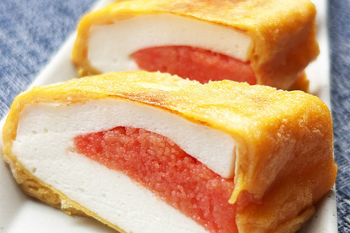 明太子を詰めた自家製卵焼きの断面図が3切れ、明るい皿に並べられています。