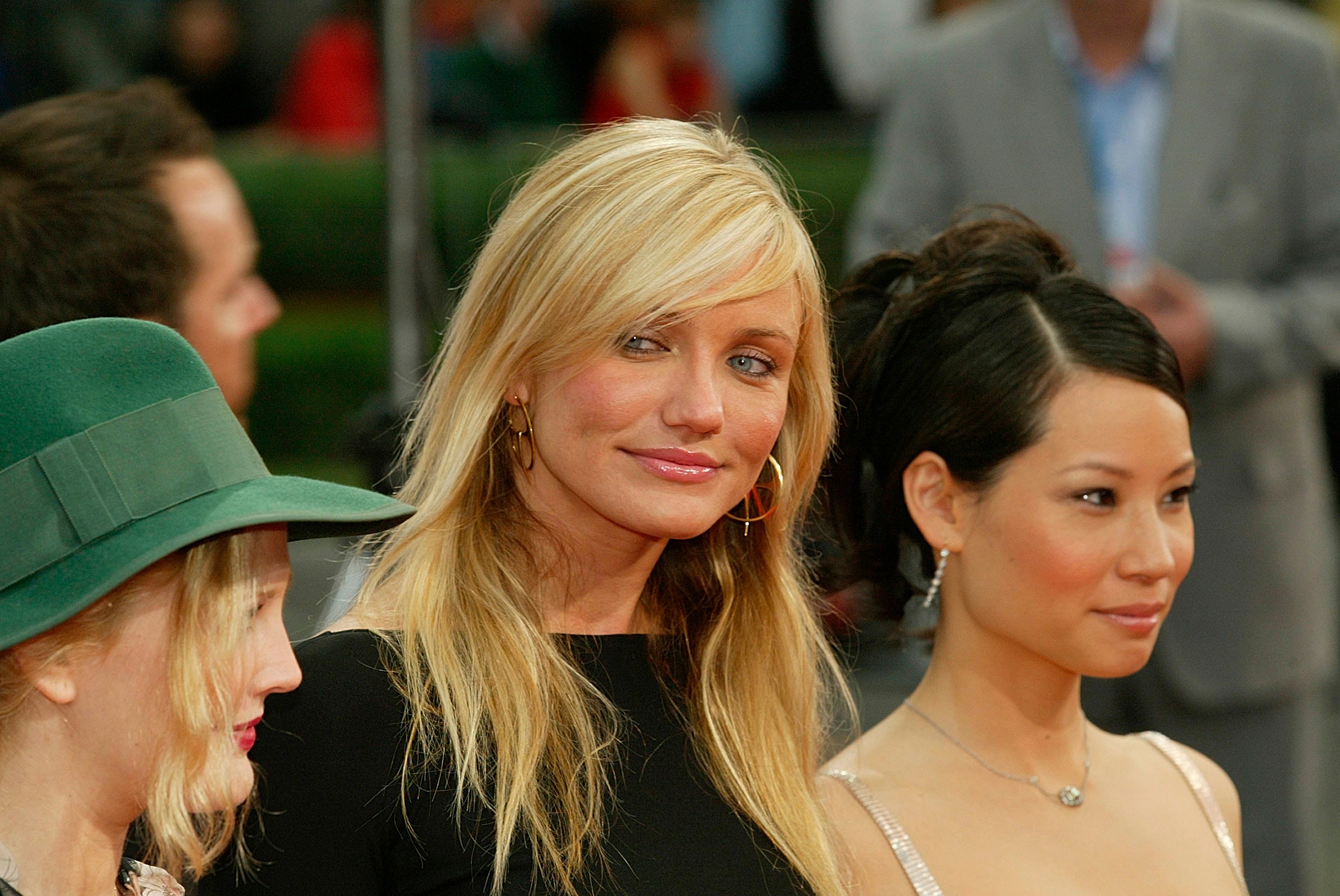 Cameron Diaz, Lucy Liu, and Drew Barrymore at an event in 2003, Cameron looking at Drew