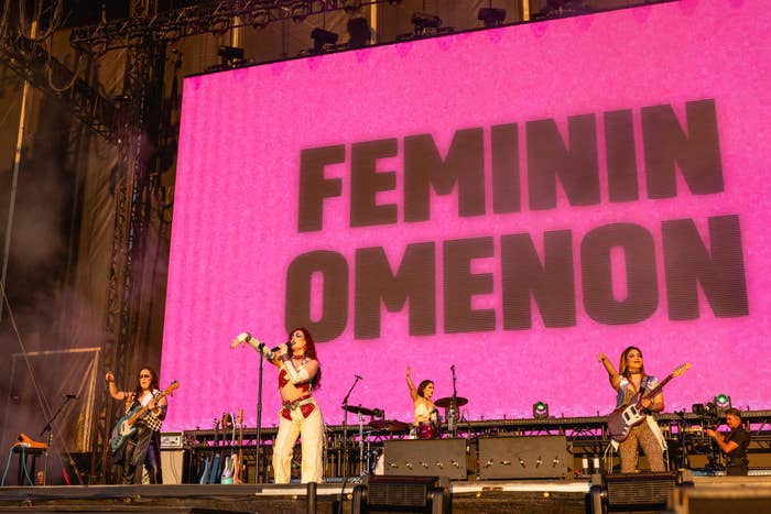 Band performs live on stage with large 