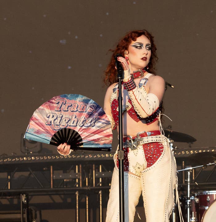 Chappell Roan on stage in studded outfit holding a fan with