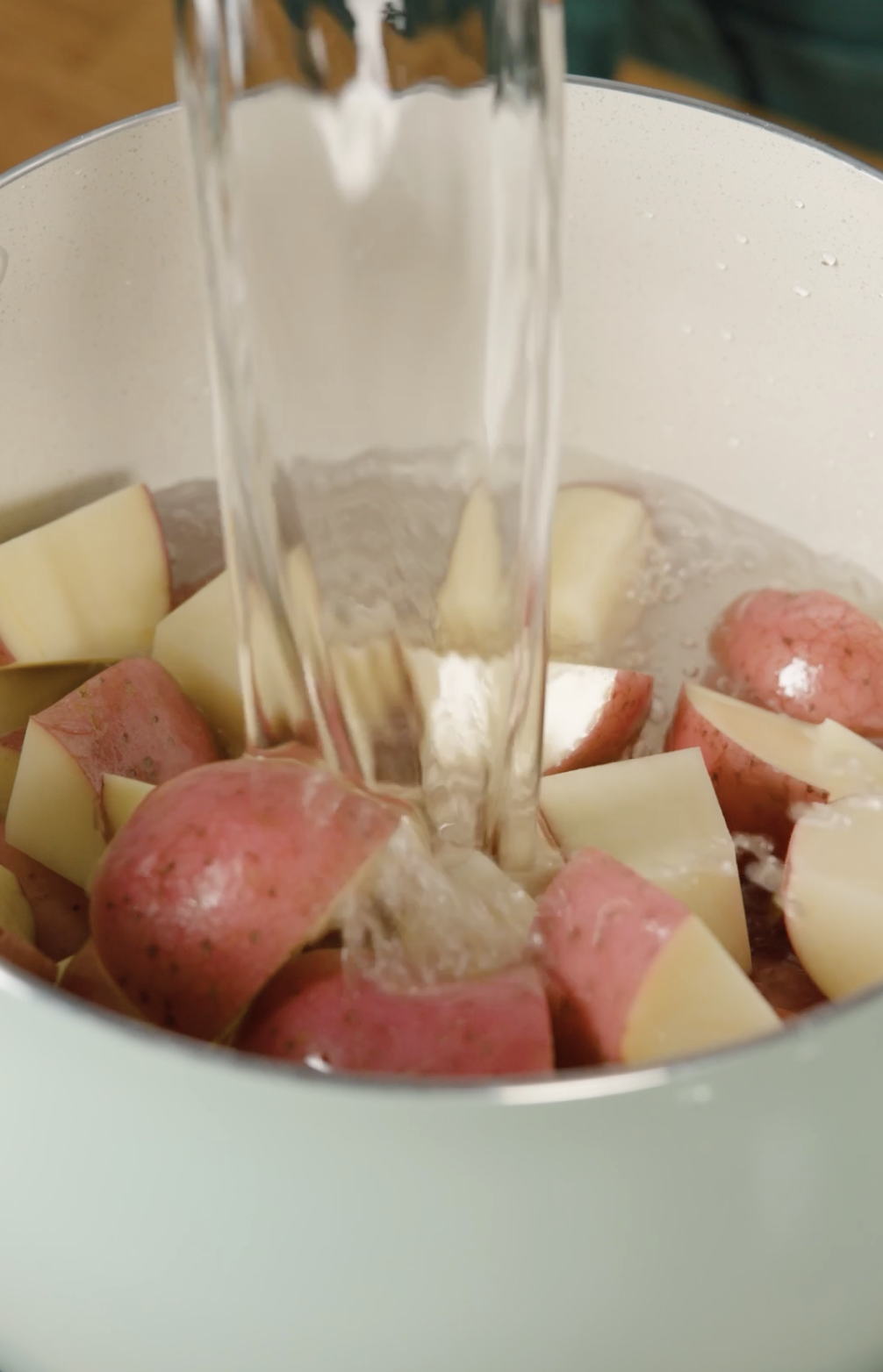 Water pouring implicit    diced reddish  potatoes successful  a pot