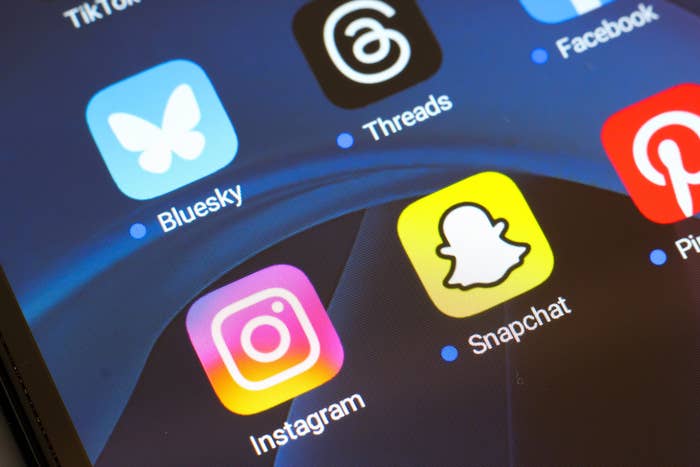 Close-up of a smartphone screen displaying apps: TikTok, Bluesky, Threads, Facebook, Instagram, Snapchat, and Pinterest