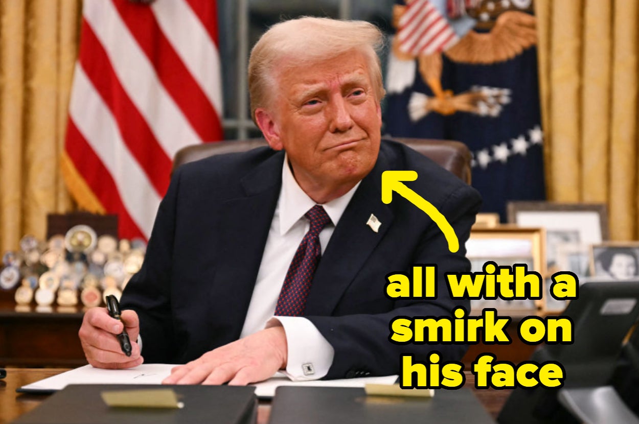 Person seated at desk in official setting, holding pen, with a smirk. Text overlay reads: "all with a smirk on his face."