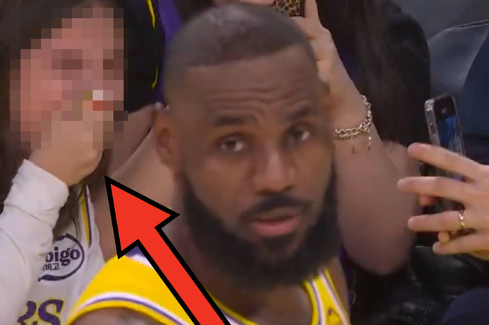 バスケットボールの試合中、ユニフォームを着た2人の選手。1人の選手がボールをドリブルしている。