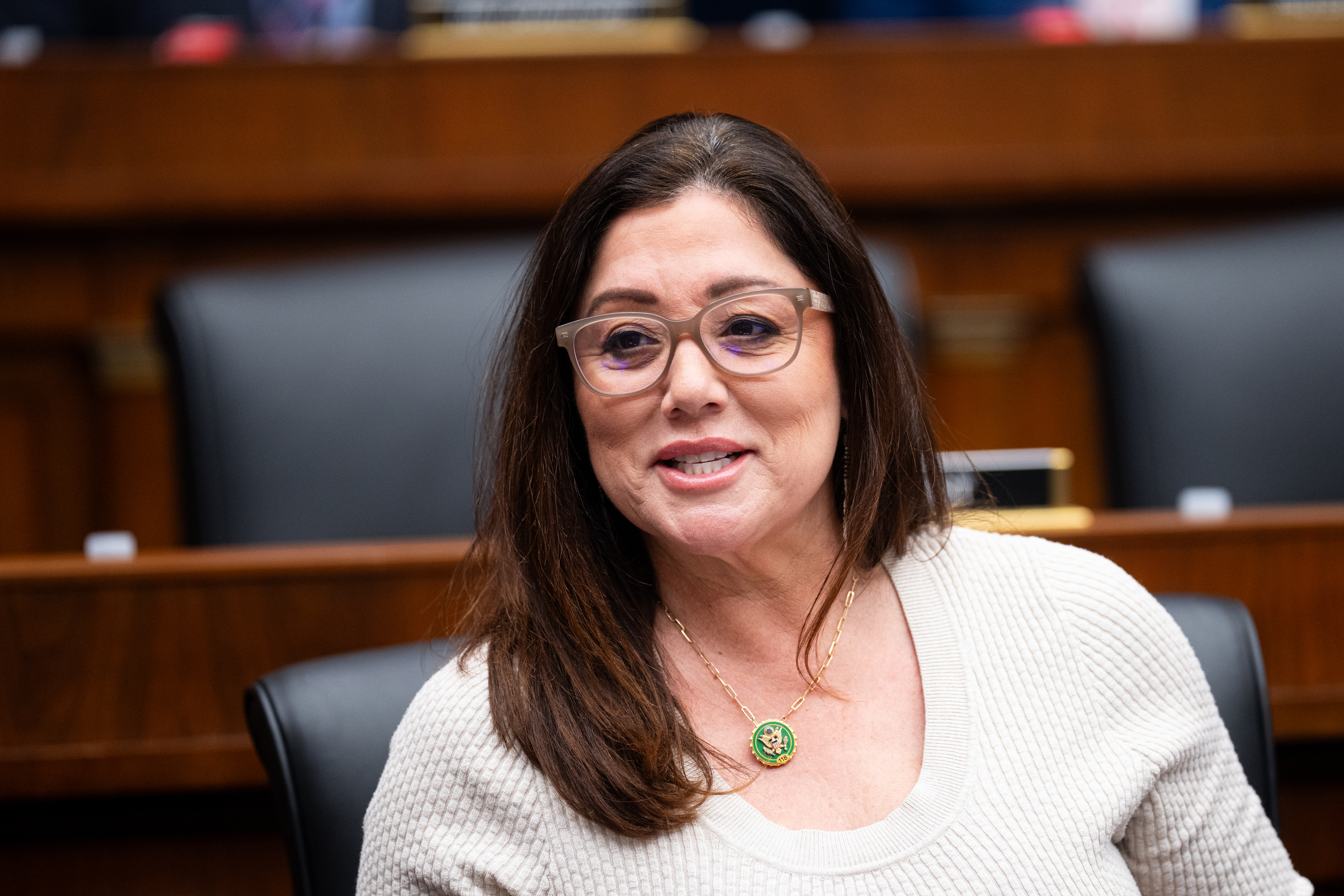Rep. Lori Chavez-DeRemer wearing a light sweater, sitting in a public setting, possibly a meeting or hearing