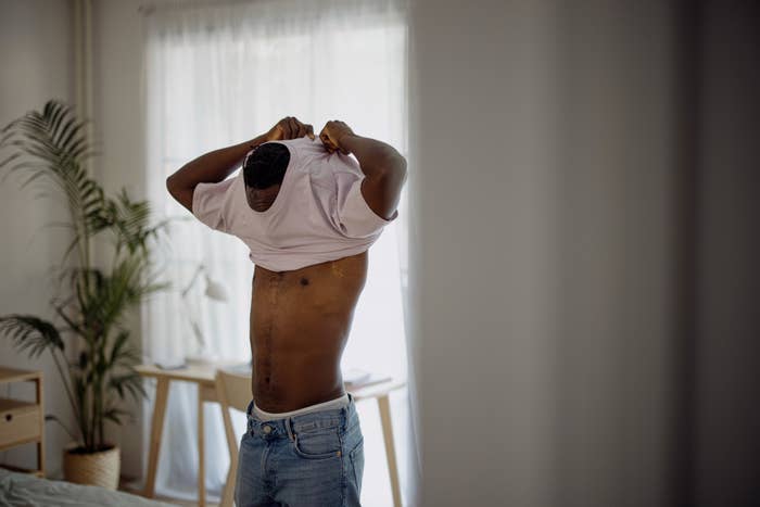 Man removing shirt, revealing toned body, sensual tension