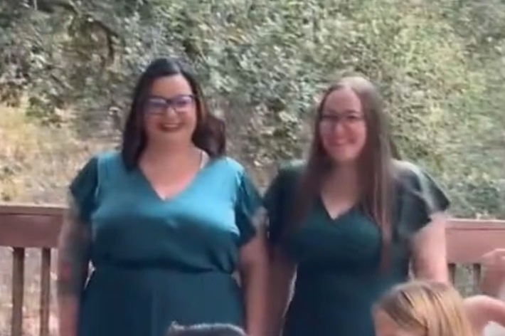 3人の女性が立っており、2人は緑のドレス、もう1人は白のドレスを着ています。背景には木々。