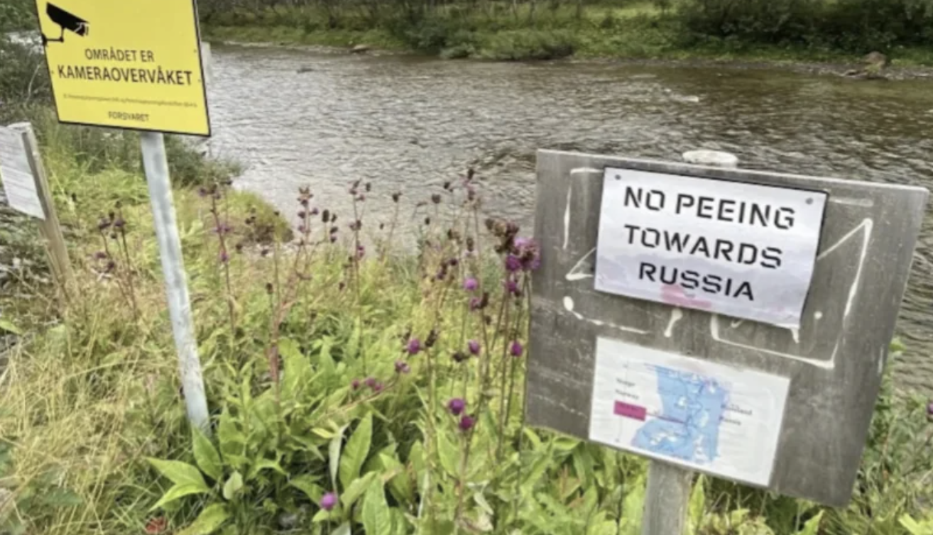 Sign by a stream  reads, "No peeing towards Russia." Another motion   successful  Norwegian mentions camera surveillance