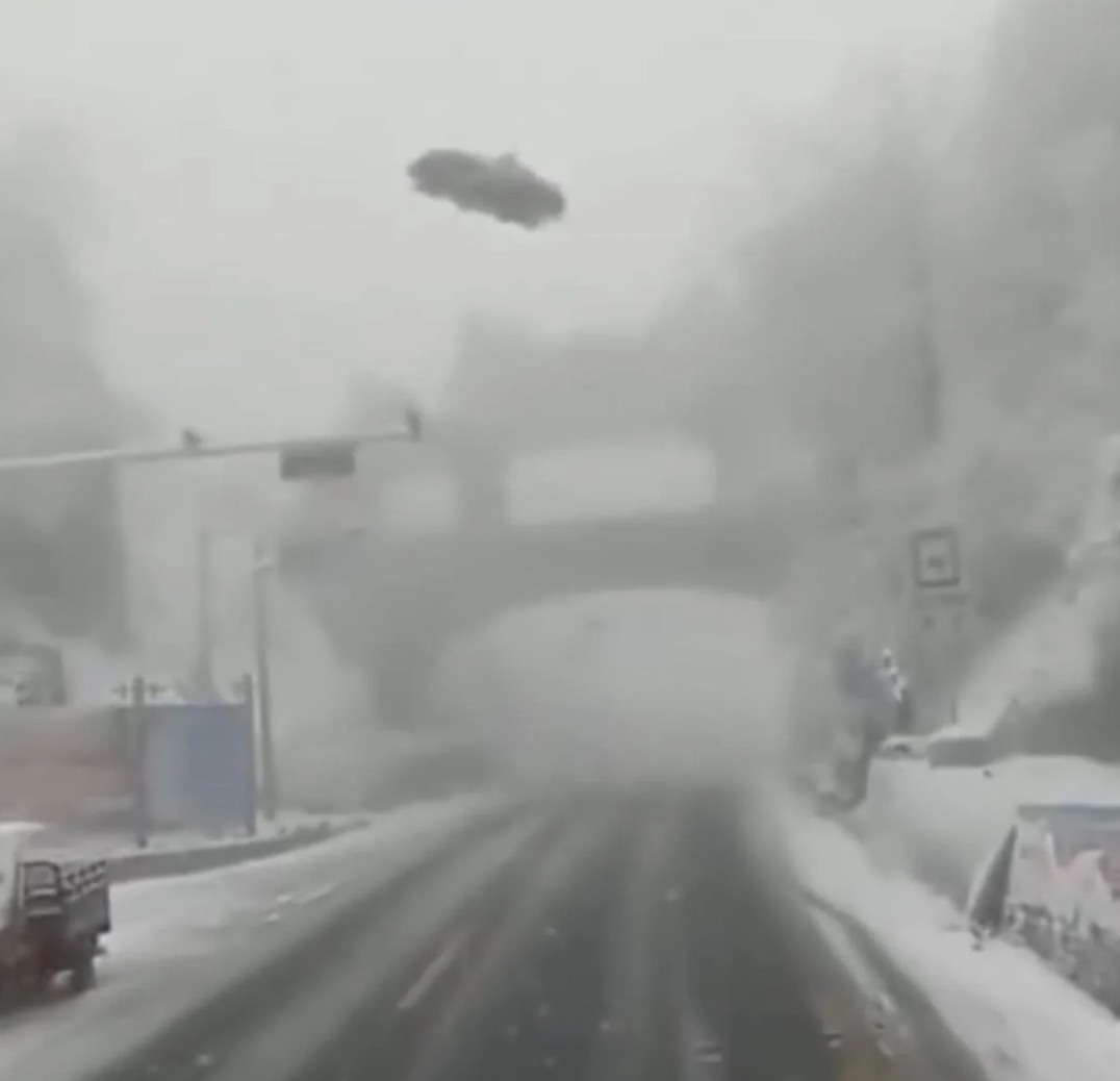 Car airborne supra  snowy roadworthy  adjacent   an overpass, suggesting a imaginable  mishap  oregon  utmost  upwind  conditions