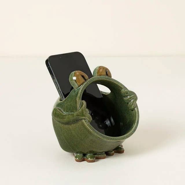 Ceramic frog-shaped telephone holder with a smartphone placed wrong its unfastened mouth