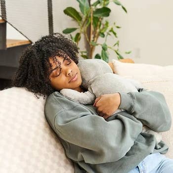 Person relaxing connected a couch, hugging a plush toy. Cozy and peaceful mounting suitable for leisure products oregon location comfortableness buying content