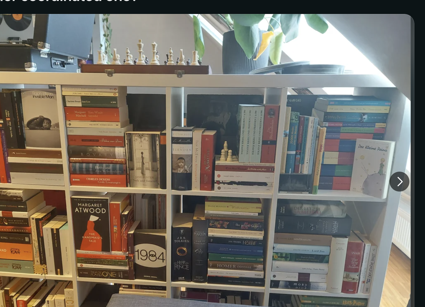 A bookshelf filled with various books is organized by genre and color. A Reddit post discusses preference for messy or coordinated bookshelves