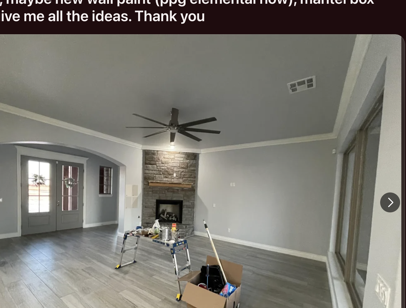 Image shows a room with gray floors, a fireplace, and a step ladder in front. A Reddit post asks for design ideas for lighting and wall paint