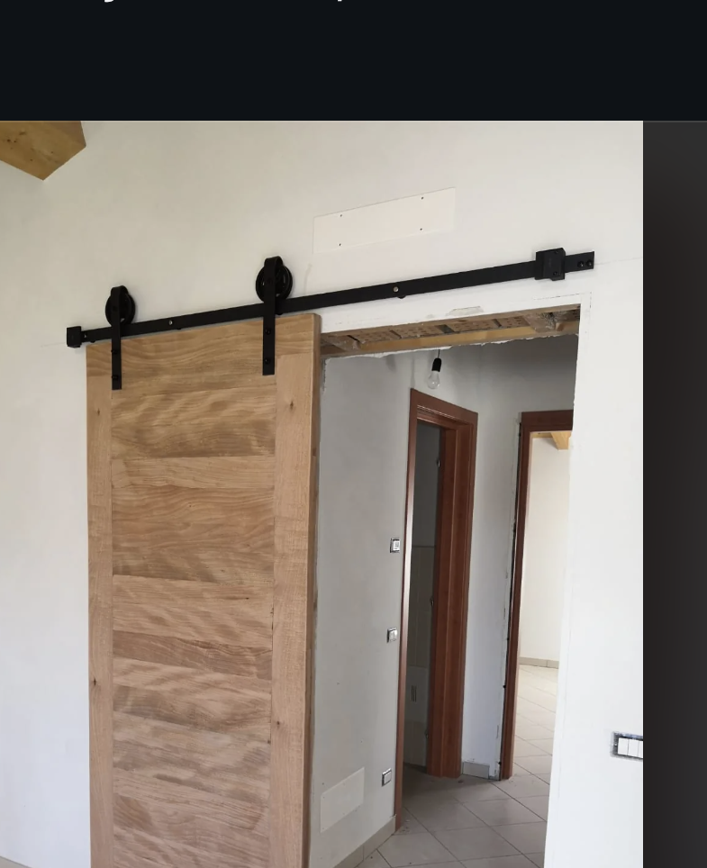 A sliding wooden door with a rustic design is shown installed in a home interior. Reddit post asks for opinions on the door made from 100% Okumé wood