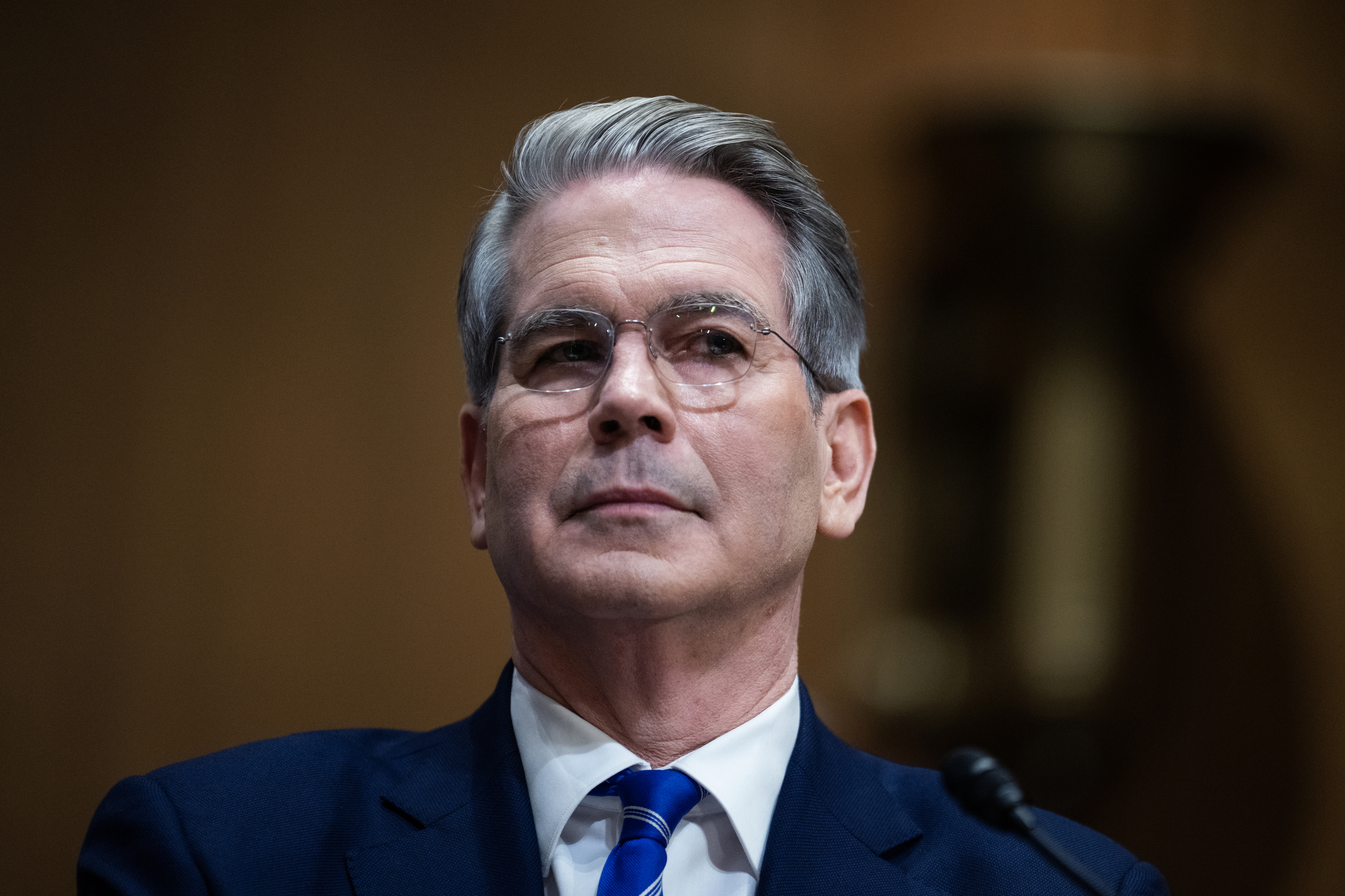 A person in a suit and tie appears thoughtful during a formal event