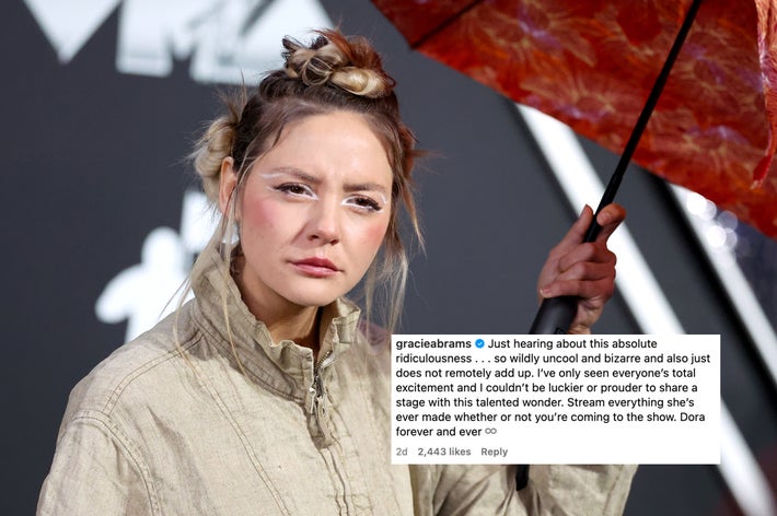 Dora Jar with high-fashion hairstyle holding a floral umbrella at a formal event