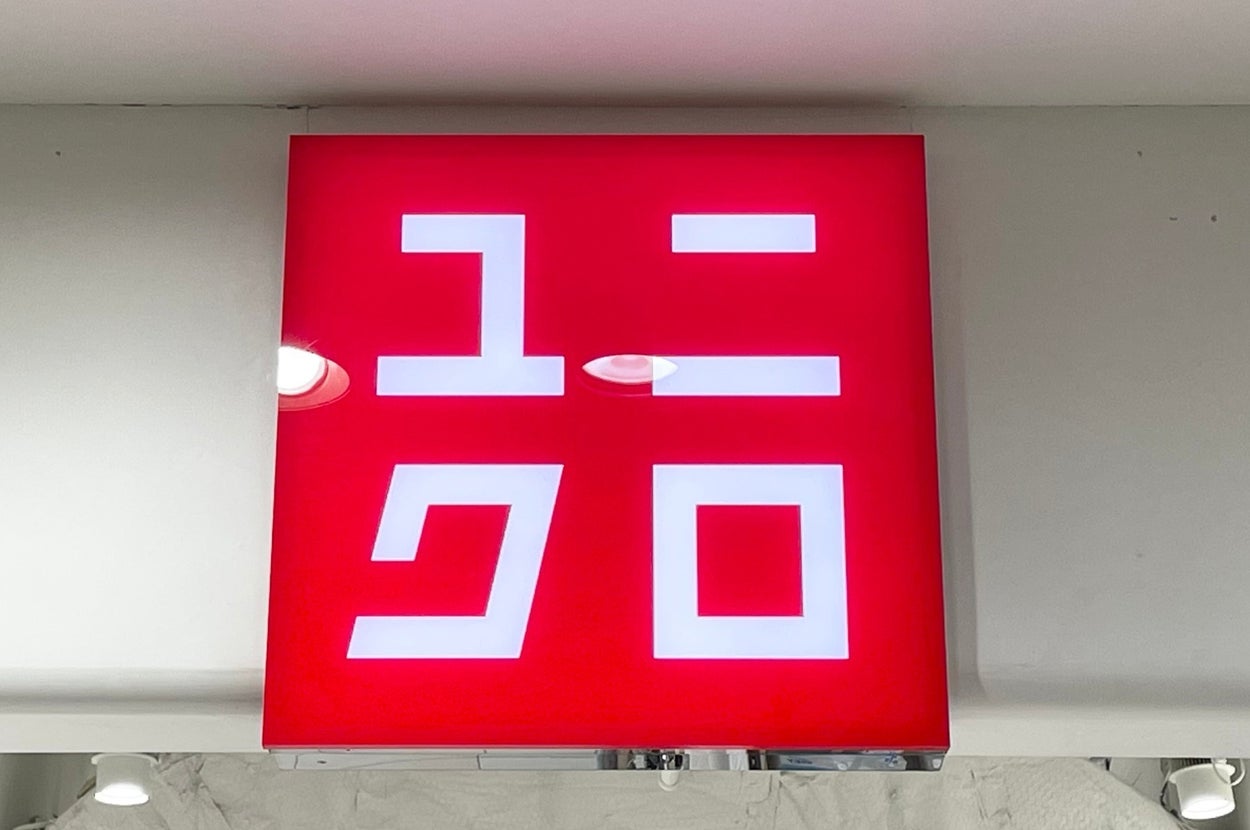 Red Uniqlo store sign with Japanese characters, displayed above a retail entrance
