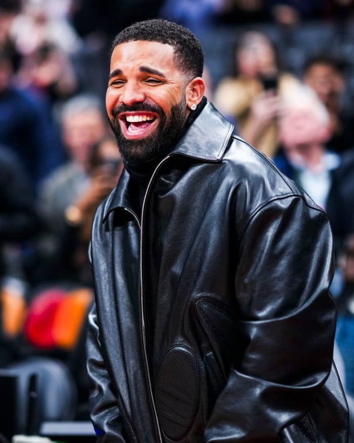 Person in a stylish leather jacket smiling broadly in a public setting