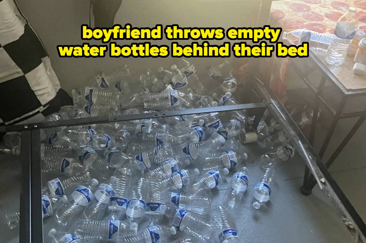 Room with numerous empty plastic water bottles on the floor behind a bed. Text reads, "boyfriend throws empty water bottles behind their bed."