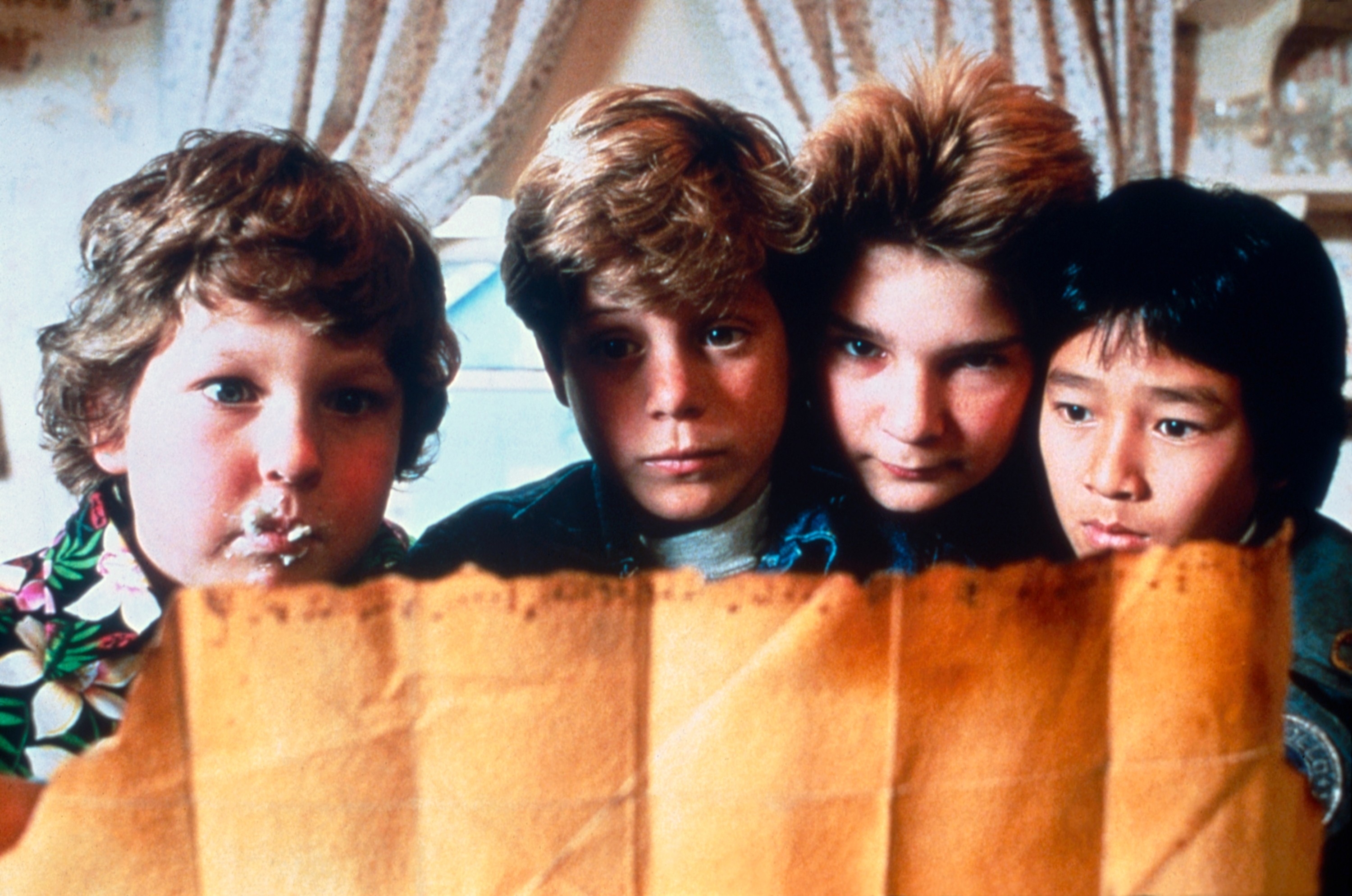 Four kids look intently at an old map