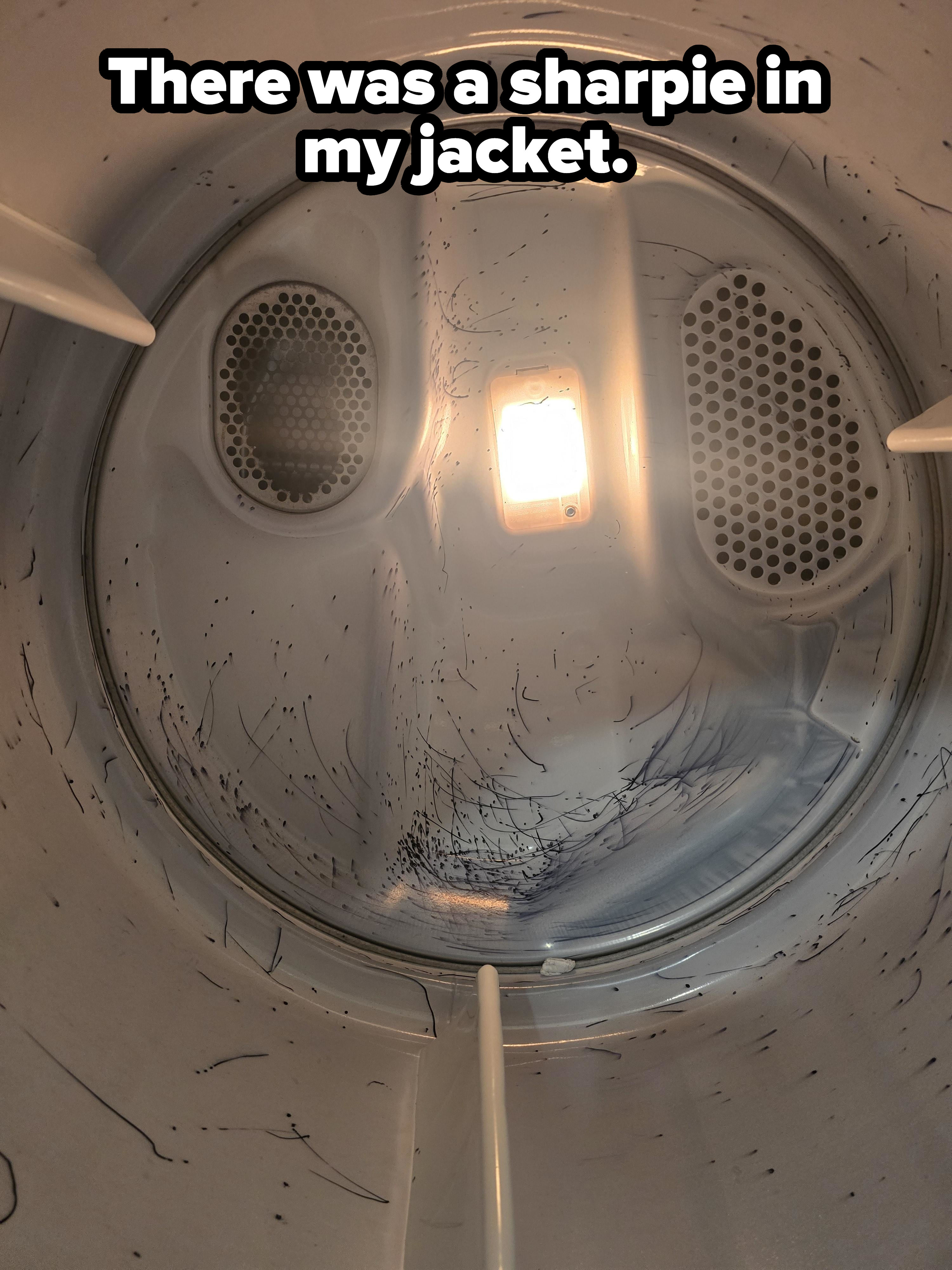 Inside view of a dryer drum with ink stains on the surfaces, light in the center illuminating the interior