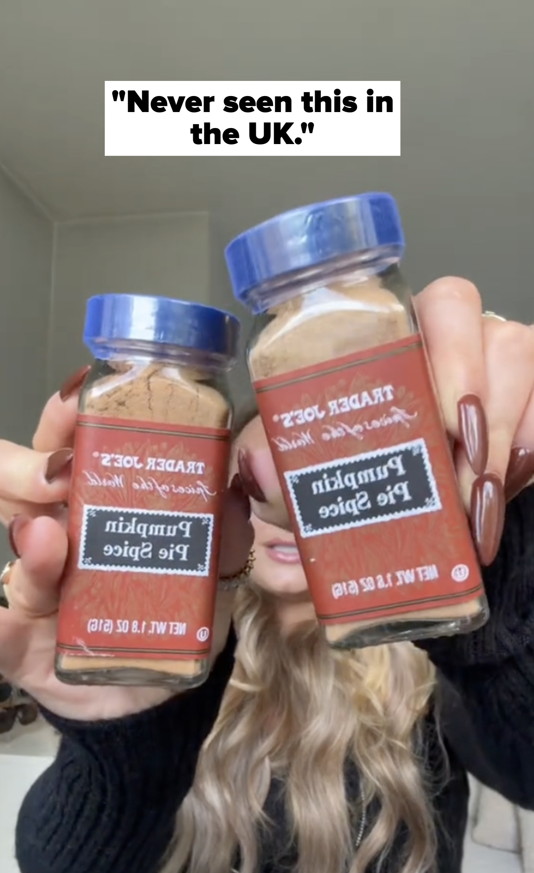 Two jars of Trader Joe&#x27;s pumpkin pie spice are held in a woman&#x27;s hands