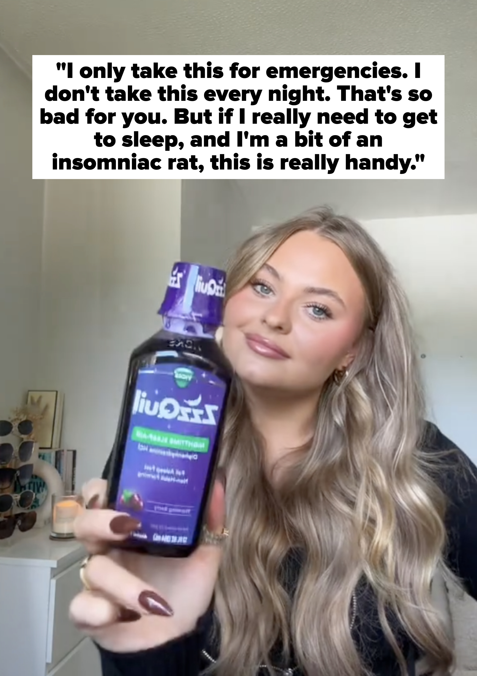 Person holding ZzzQuil bottle, smiling in a room with a shelf in the background. The focus is on displaying the product