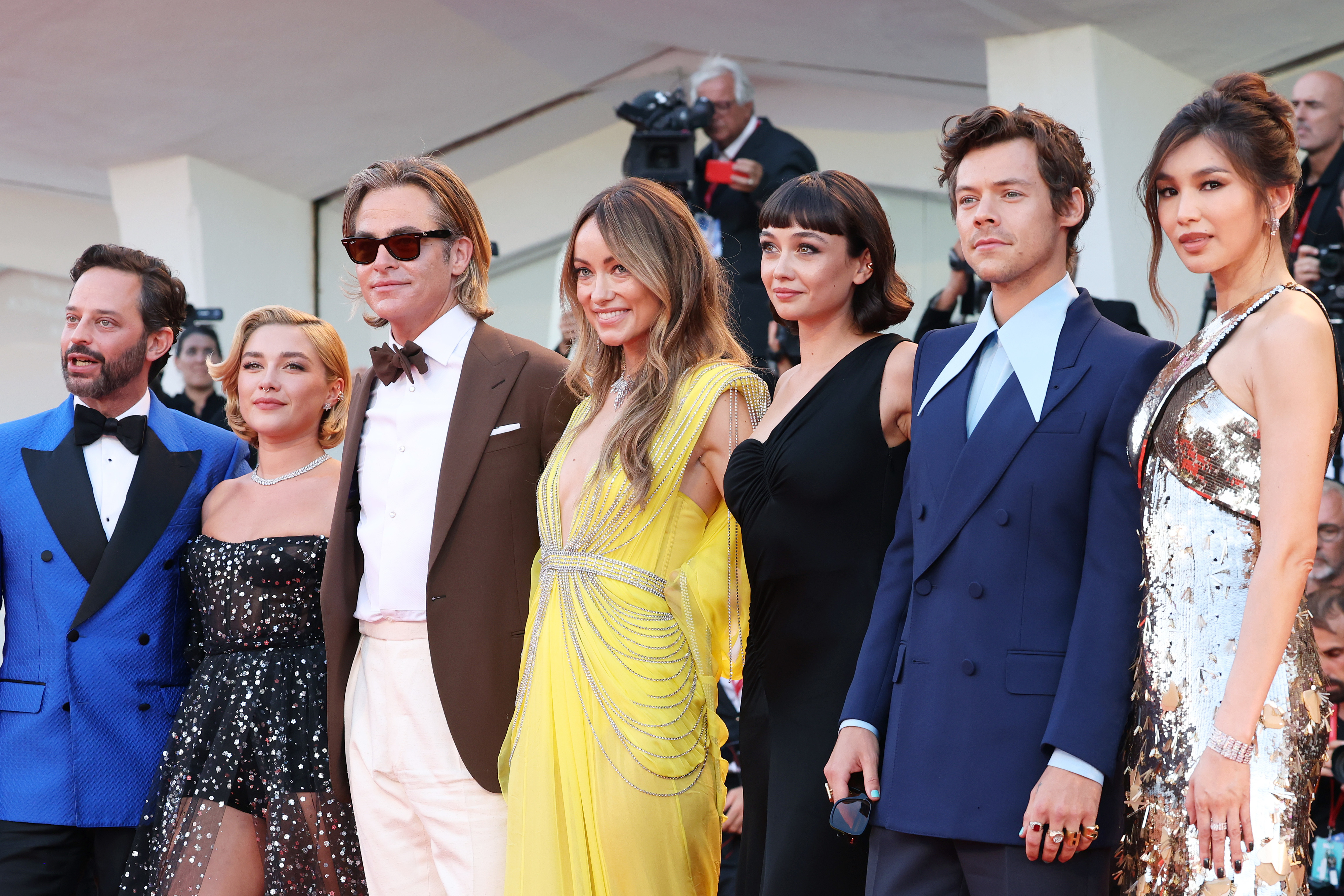 Group of actors pose on the red carpet, wearing formal and stylish attire, including suits and elegant dresses