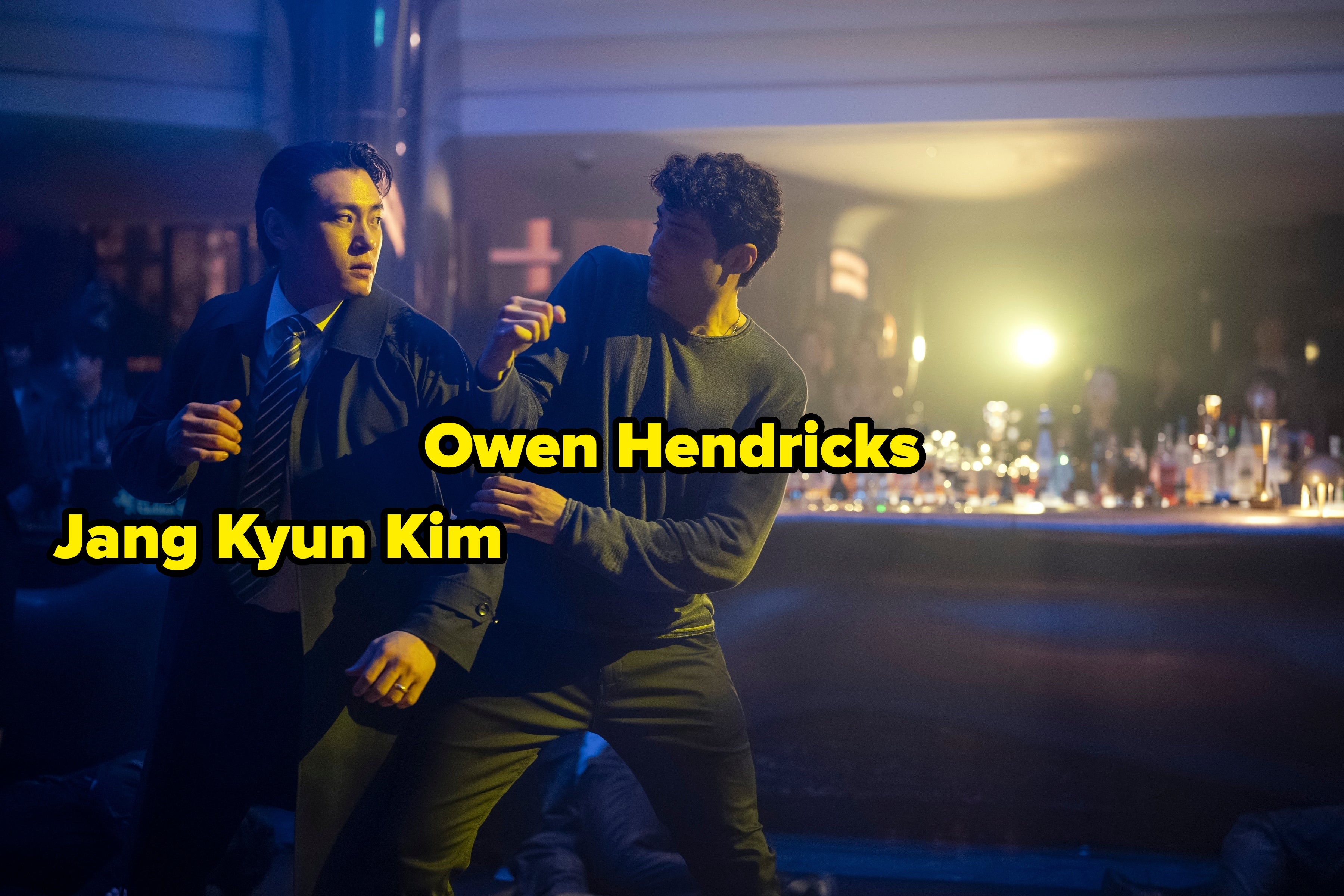 Two individuals in an intense scene appear to be engaged in a confrontation in a dimly lit bar setting