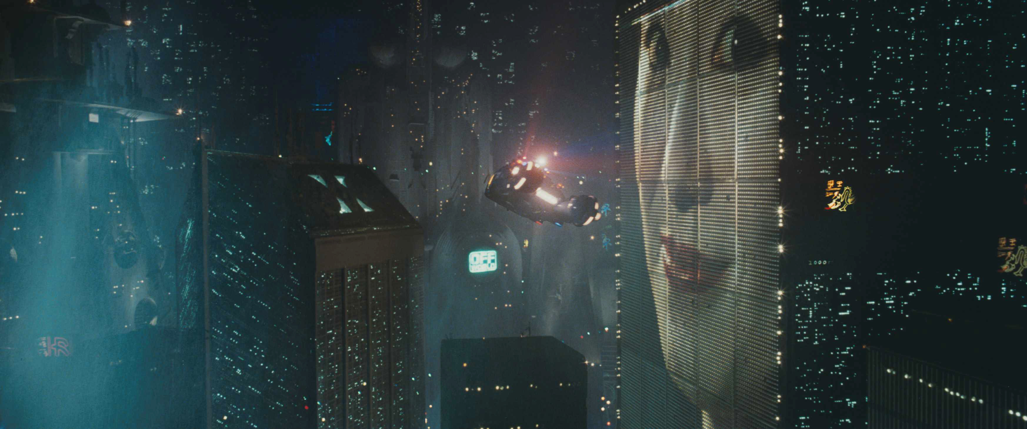 Futuristic cityscape with flying car near a building displaying a giant woman's face on a digital billboard