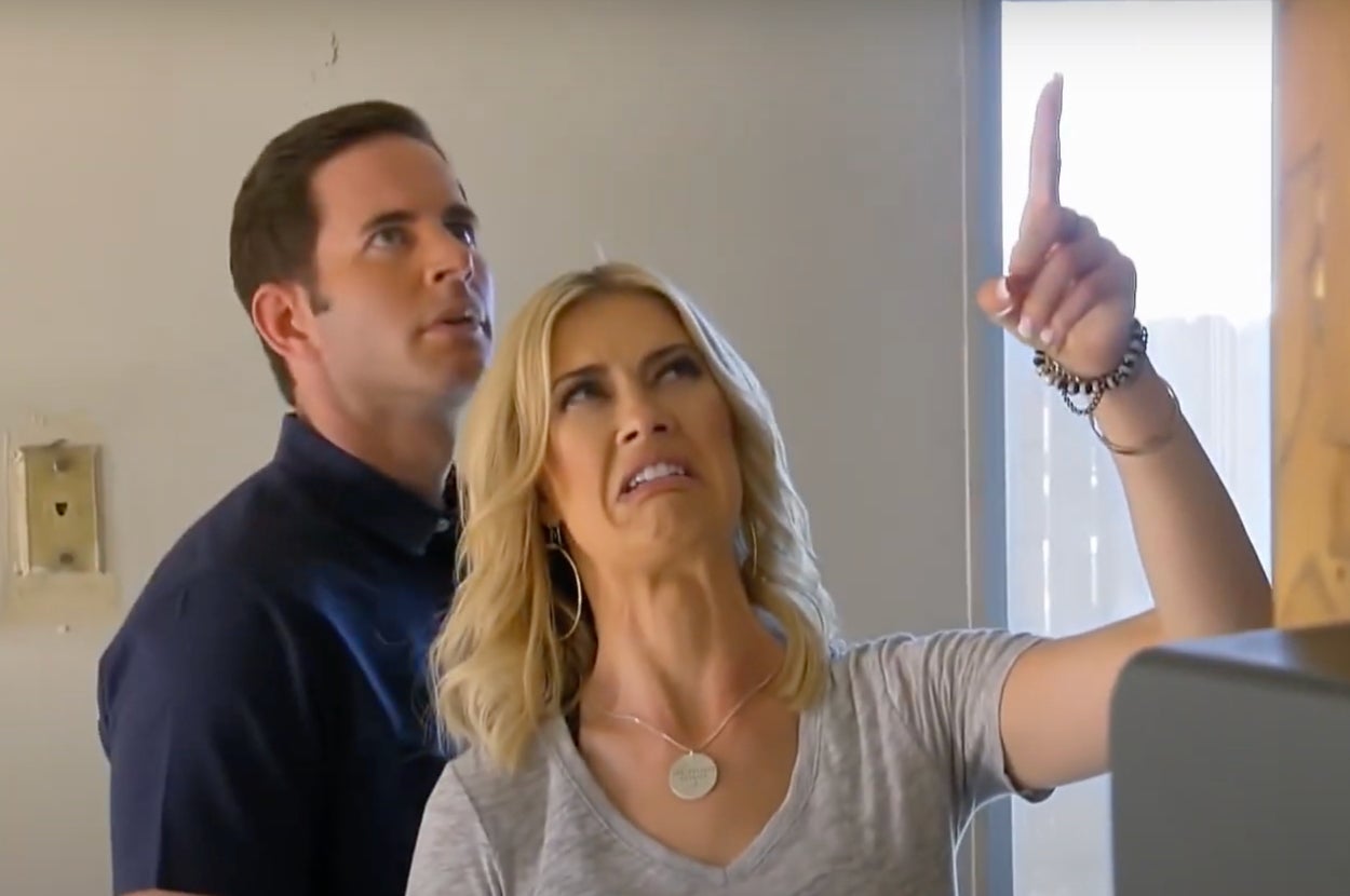 Tarek and Christina on an HGTV show. Christina points upwards with a disgusted expression on a renovation project site