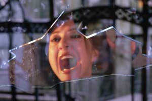 A person screams in the reflection of a shattered glass pane in a dramatic scene from Spider-Man 2