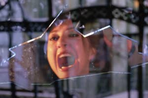 A person screams in the reflection of a shattered glass pane in a dramatic scene from Spider-Man 2