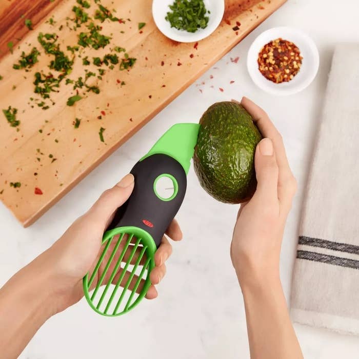 Person utilizing an avocado slicer instrumentality to chopped an avocado connected a room counter