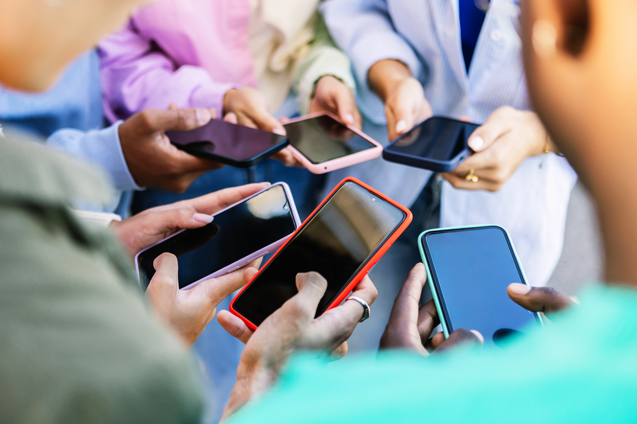 Group of people holding and using smartphones in a social setting