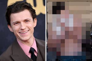 Smiling male celebrity wearing a pink shirt and suit jacket at an event, standing on a carpet