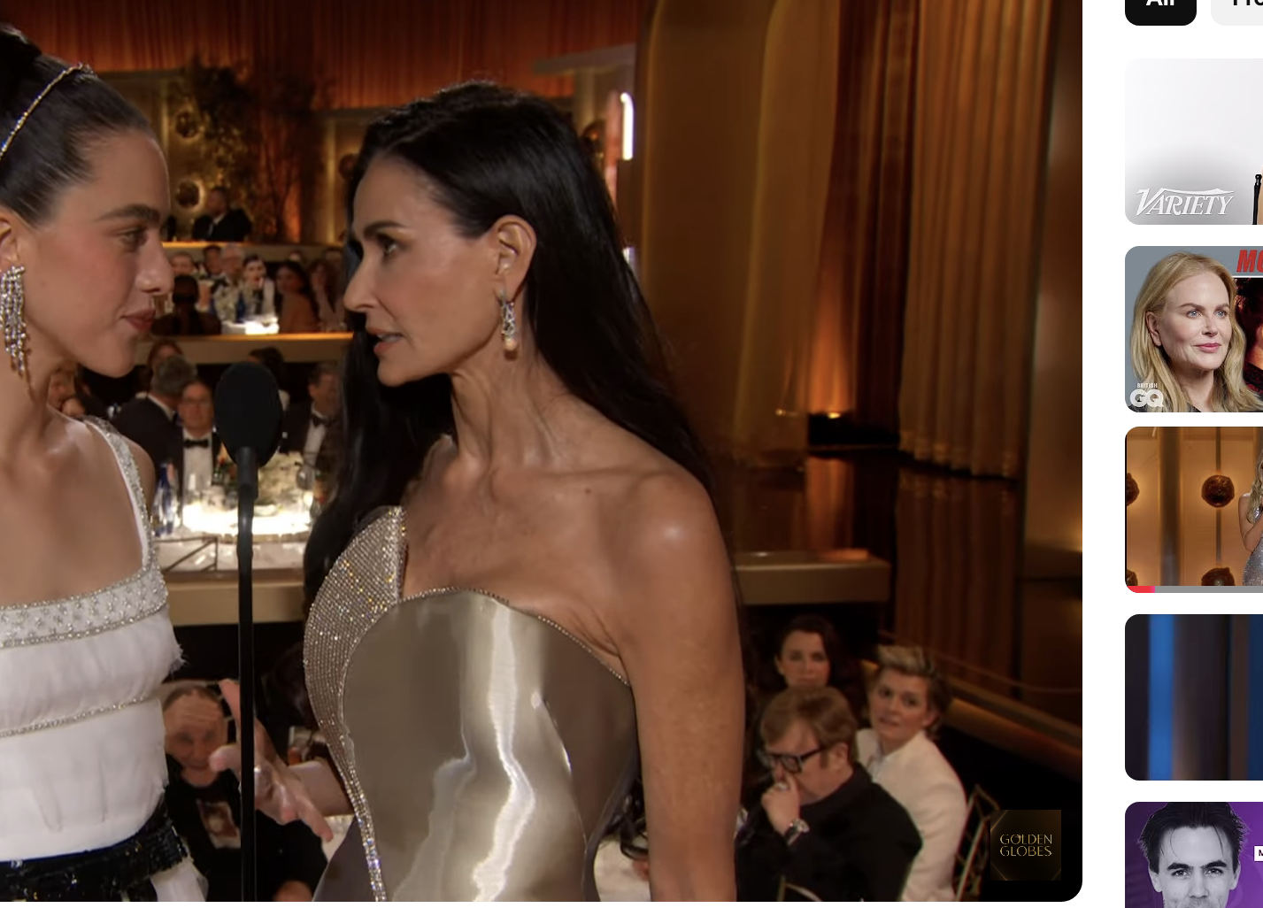 Demi Moore and Margaret Qualley stand face to face while presenting an award at the Golden Globes