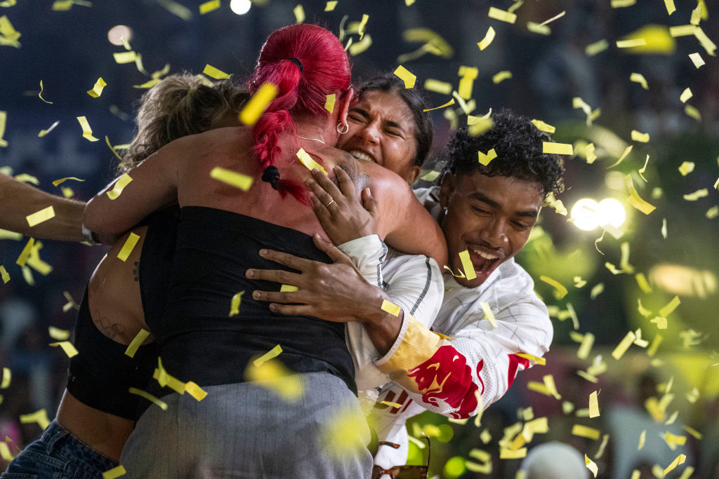 Group of people hugging in a joyful celebration surrounded by floating confetti