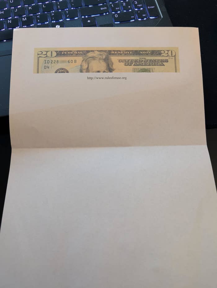 A $20 bill appears partially inside a folded paper with the text &quot;www.rulesforuse.org&quot; visible