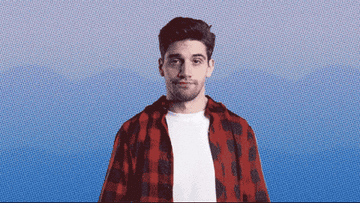 Person faces forward, raises both hands, and shrugs slightly. Wearing a checkered shirt over a T-shirt, the background is a blue gradient