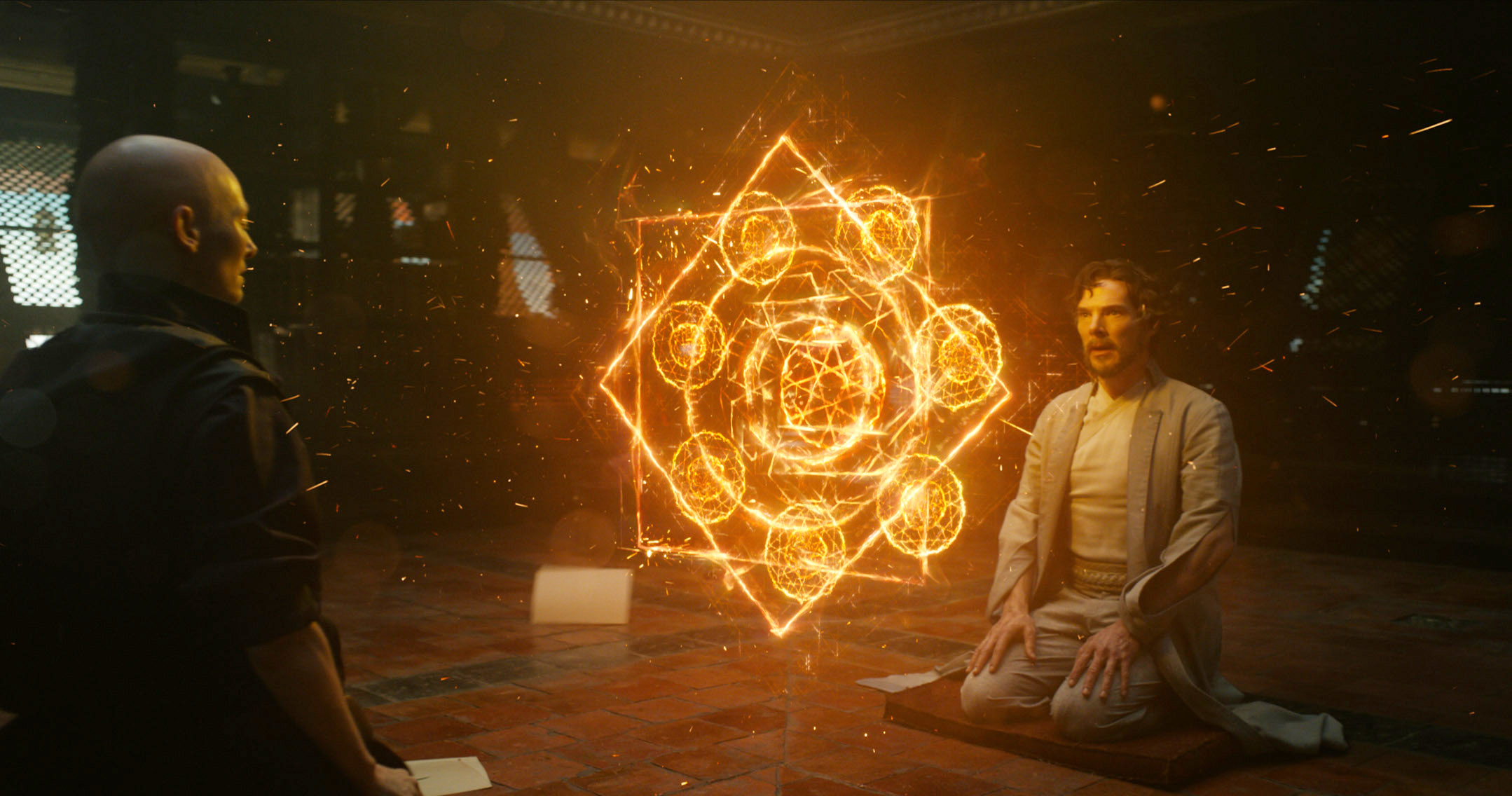 Mystical scene with two characters, one kneeling, surrounded by glowing geometric patterns in a dim room, suggesting magic or supernatural elements