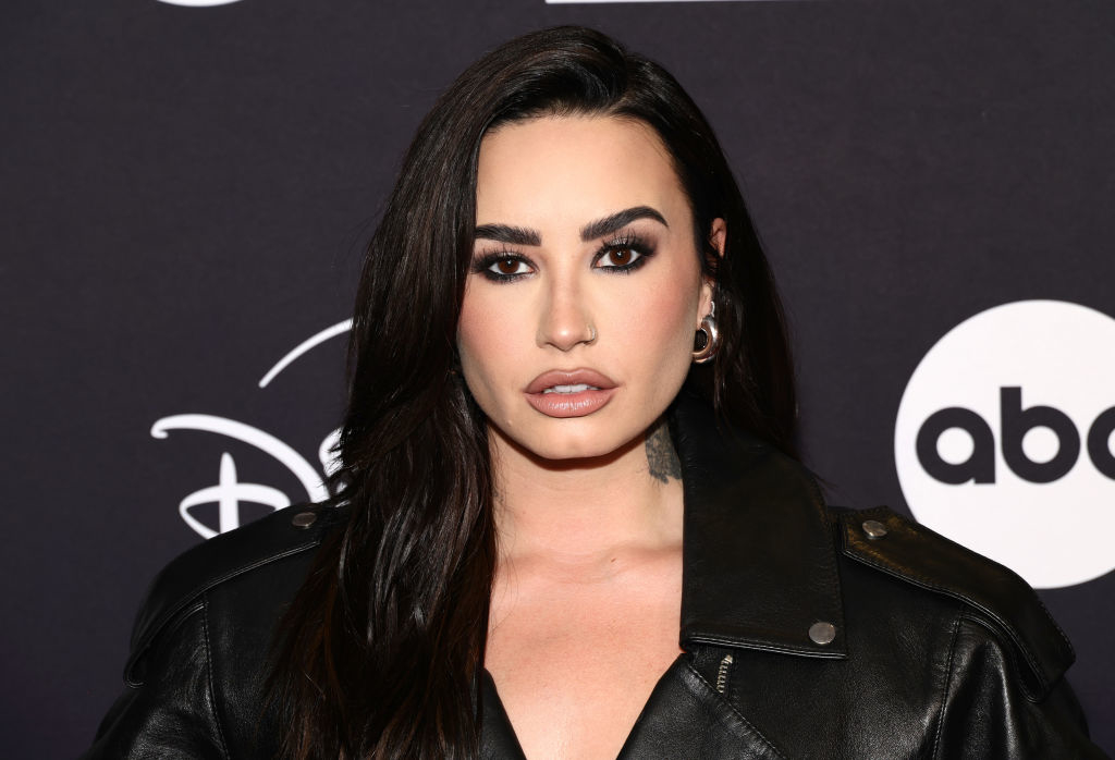 Person in a leather jacket at a media event, posing against a backdrop with Disney and ABC logos